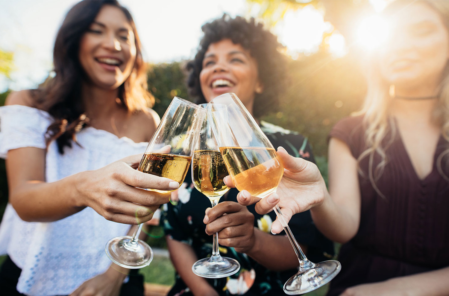 three ladies smiling with glass of bubbly