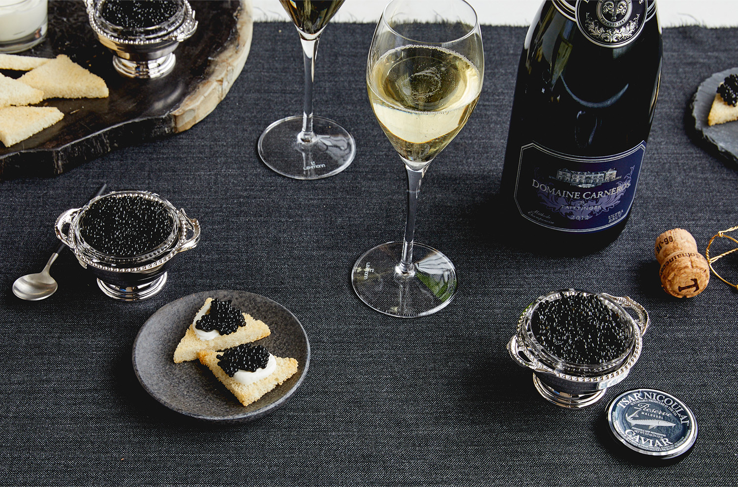 Caviar bowl on tablecloth with bottle of Ultra Brut