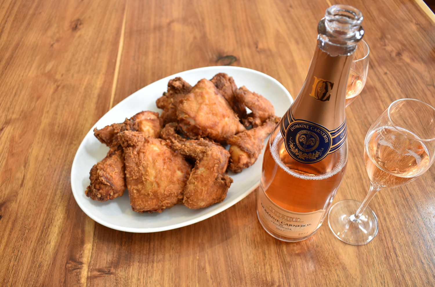 Plate of fried chicken with Domaine Carneros Brut Rosé Bottle